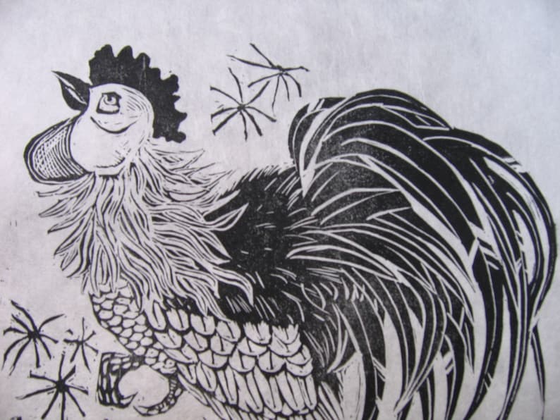 May include: Black and white linocut print of a rooster with a large comb and wattles. The rooster is facing to the right and has its wings spread out. The background is a light gray.