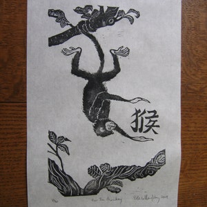 May include: Black and white woodblock print of a monkey hanging upside down from a tree branch. The monkey is labeled "猴" in Chinese characters. The print is titled "Howl the Monkey" and signed "Elle Willoughby, 2007".