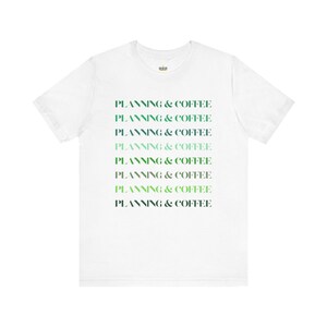 May include: White t-shirt with the text "PLANNING & COFFEE" repeated eight times in a gradient of green and blue.