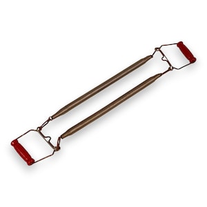 May include: A vintage chest expander with two bronze-colored springs and red handles. The handles are rectangular and made of a hard, smooth material. The springs are connected to the handles with a wire frame.