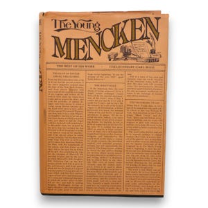 May include: The cover of a vintage book titled "The Young Mencken: The Best of His Work" by H.L. Mencken, collected by Carl Bode. The cover is a tan color with black text and illustrations. The book features a quote from the book, "Trials of an Editor Among the Cliches".
