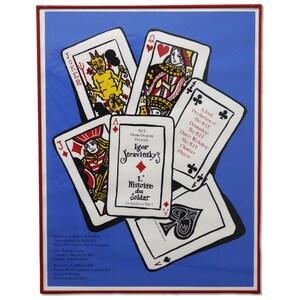 Puede incluir: Un póster con fondo azul y borde rojo presenta naipes dispuestos alrededor de una carta central. La carta central dice "Igor Stravinsky's L'Histoire du Soldat". Otras cartas incluyen un Joker, una Reina, una Jota y un As.