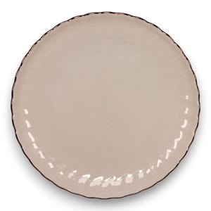 May include: A round, light beige plate with a wavy edge and a dark brown rim. The plate has a smooth surface and is suitable for serving food. The plate is a neutral color and can be used for various occasions.