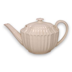 May include: Cream-colored ceramic teapot with a lid and handle. The teapot has a ribbed design on the body and lid, and a curved spout. The handle is a simple loop shape. The teapot is designed for brewing and serving tea.