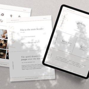 May include: A digital tablet displaying a brand board for a company called "Kin & Co." The board features a primary logo with the text "Kin & Co." and a hand holding a small circle. The board also includes a secondary logo with the text "Kin & Co." and a hand holding a small circle. The board also includes a list of brand values, including "community", "quality", "ethical", "design", "calm", "digital", "modern", "joy", "future", "enquiry", "relationships", "appreciation", "style", and "evolve."