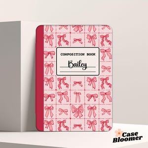 May include: Pink composition book with a red spine and a pattern of pink bows on a white background. The book says "COMPOSITION BOOK" and "Bailey" on the front.
