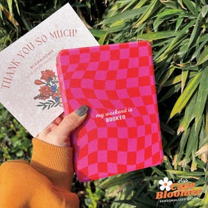 May include: A pink and red chequered phone case with the text "my weekend is BOOKED." A thank you card with floral illustrations and the text "THANK YOU SO MUCH!" is also visible.