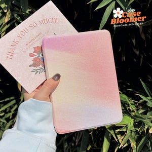 May include: A pink, white, and yellow ombre phone case with a textured finish. The case is made by Case Bloomer, a company that makes personalized cases.