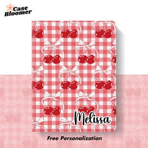Puede incluir: Un patr&oacute;n de cuadros vichy rojo y blanco con un dise&ntilde;o repetido de cerezas rojas con tallos y lazos blancos. El texto "Melissa" est&aacute; escrito en blanco en cursiva en la parte inferior de la imagen. El texto "Personalizaci&oacute;n gratuita" est&aacute; escrito en negro en la parte inferior de la imagen.