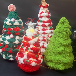 Pode incluir: Quatro decorações de árvore de Natal em forma de cone feitas de fio texturizado. Uma é verde-escura com detalhes vermelhos e brancos e ornamentos de doces, uma é vermelha e branca com luzes e uma estrela, uma é vermelha e branca, e uma é verde-clara.