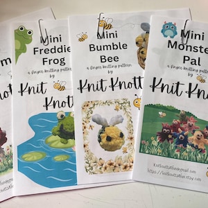 May include: Four printed patterns for finger knitting, featuring designs like a mushroom, frog, bumble bee, and monster pal. Each pattern is titled with the design name and the words "Knit Knotts" in a bold font. The patterns are held together with paper clips.