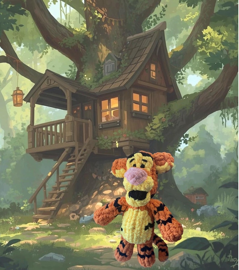 May include: A crocheted Tigger plush toy stands in front of a detailed illustration of a treehouse. The plush features orange and yellow yarn with black stripes, a pink nose, and black eyes. The treehouse is brown with a small porch and a hanging lantern.