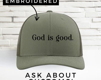 Może przedstawiać: Oliwkowa czapka typu trucker z haftowanym napisem "God is good." Czapka ma siatkowy tył i zakrzywiony daszek. Tekst "EMBROIDERED" znajduje się nad czapką, a "ASK ABOUT CUSTOMS!" pod nią.