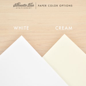 May include: Two paper samples, one white and one cream, are displayed on a woodgrain background. The text "Silhouette Blue - Stationery -" and "PAPER COLOR OPTIONS" are at the top of the image. The words "WHITE" and "CREAM" are written below the paper samples.