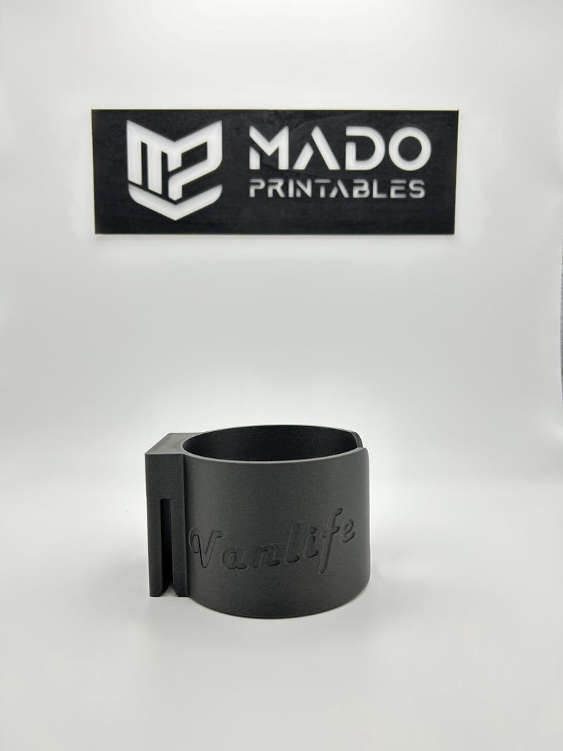 May include: A gray 3D printed cup holder with the word "Vanlife" printed on the side.