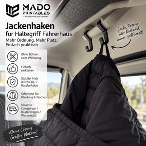 Può includere: Due ganci in plastica nera fissati alla maniglia di sostegno di un veicolo, che reggono una giacca trapuntata nera. L'immagine contiene testo: MADO PRINTABLES, Jackenhaken für Haltegriff Fahrerhaus, Mehr Ordnung. Mehr Platz. Einfach praktisch, Ohne Bohren, Einfach einklicken, Stabiler Halt, Schonend für Kleidung, Ideal für Campervan, Kleine Lösung. Großer Nutzen, Jacke, Tasche oder Rucksack immer griffbereit.