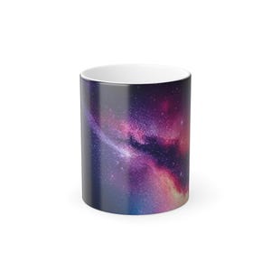 Puede incluir: Una taza de café de cerámica con un diseño de galaxia. La taza presenta una vívida representación de una nebulosa con tonos de púrpura, rosa y azul. El interior de la taza es blanco y el exterior tiene un acabado brillante.