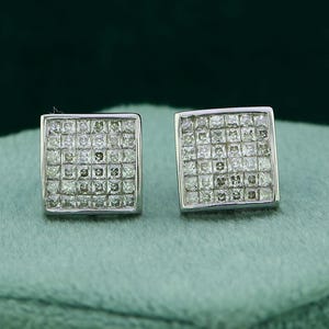 May include: A pair of square-shaped diamond earrings set in silver. The earrings are made of small, closely set diamonds.