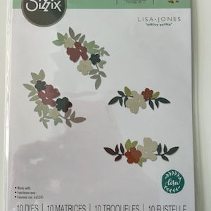May include: A package of 10 die cuts featuring floral designs in shades of red, green, and brown. The package is labeled "Sizzix Thinlits" and "Lisa Jones". The die cuts are designed to work with the Sizzix machine, model 665281.
