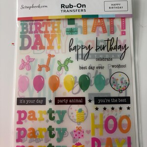 May include: A sheet of Rub-On Transfers for scrapbooking. The sheet includes colorful text and images such as balloons, gifts, and the words "Happy Birthday", "Party", and "Hooray!"