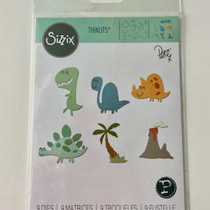 Op de afbeelding: Een verpakking met negen uitgestanste dinosaurusvormen voor knutselen. De verpakking bevat een groene T-Rex, een blauwe stegosaurus, een gele triceratops, een groene stekelige dinosaurus, een bruine palmboom en een bruine vulkaan. De verpakking is gelabeld met "Sizzix Thinlits" en "664393".