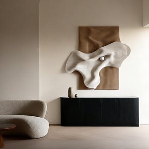 May include: A modern interior featuring a black cabinet, a beige sofa, and a wooden coffee table. A large, abstract, white sculpture with a sphere is mounted on a brown backdrop on the wall. The room has a neutral color palette.