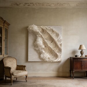 May include: A large, square, abstract wall art piece with a textured, layered design in shades of white and cream. The artwork features a wave-like pattern with a fluffy, cloud-like element. The piece is mounted on a neutral-coloured wall.