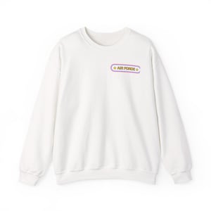 Könnte beinhalten: Ein weißes Sweatshirt mit Rundhalsausschnitt und langen Ärmeln. Das Sweatshirt hat ein kleines rechteckiges Design auf der Brust mit dem Schriftzug "AIR FORCE" in einer stilisierten Schriftart, umrandet in Lila und Gelb, mit Sternakzenten.
