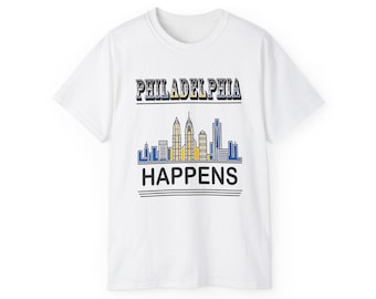 May include: White t-shirt with the text "PHILADELPHIA HAPPENS" in a stylized font. The design includes a skyline graphic in blue and yellow. A casual, everyday apparel item.