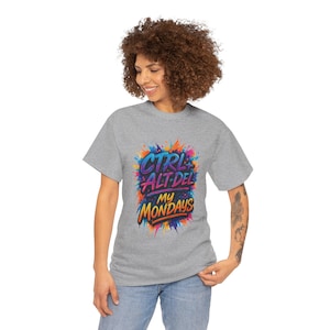 Puede incluir: Una camiseta gris con el texto "CTRL ALT DEL MY MONDAYS" en un diseño colorido estilo grafiti. El texto es en azul, morado, naranja y amarillo. La camiseta está hecha de un material suave.