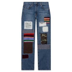Pode incluir: Jeans azuis com vários patches de tecido costurados na frente. Os patches incluem listras tecidas, camuflagem e quadrados texturizados. Os jeans têm um design clássico de cinco bolsos.
