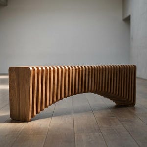May include: A modern wooden bench with a unique design. The bench is made of light brown wood and features a curved, slatted design. The bench is approximately 60 inches long and 16 inches high.