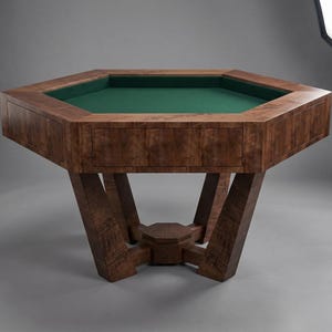 May include: A large, octagonal wooden game table with a green felt playing surface. The table has a rich, dark wood grain finish and sturdy, angled legs. The table is designed for games like poker or board games.
