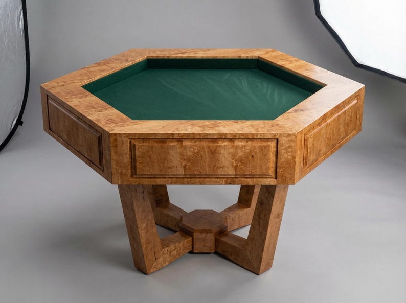 May include: A wooden octagonal poker table with a green felt playing surface. The table has a light brown, burl wood finish and a geometric base. The table is approximately 40 inches wide and 30 inches tall.