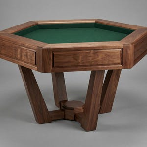 May include: A solid wood, octagonal game table with a green felt playing surface. The table has a rich, dark brown finish and features decorative drawer fronts. The legs are angled and provide a sturdy base for the table.