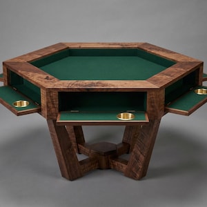 May include: A wooden octagonal poker table with a green felt playing surface. The table has pull-out trays with brass cup holders and is supported by a sturdy, angled base. The wood has a rich, dark finish.
