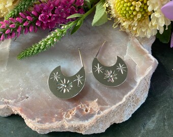 Pequeños aros de plata con margaritas y estrellas grabadas