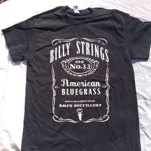 May include: Black t-shirt with a white graphic that reads "BILLY STRINGS Old No. 33 American Bluegrass." The graphic is designed to resemble a whiskey label. Below the text is "DISTILLED & BOTTLED BY BMFS DISTILLERY USA."