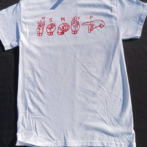 May include: White t-shirt with red sign language hand gestures spelling out "W S M T F P".