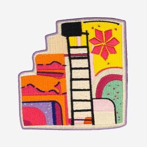 May include: Embroidered patch with a colorful abstract design. The patch features a black ladder, a pink flower, and various geometric shapes in orange, yellow, and purple. The patch has a purple border.