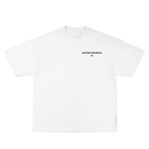 May include: A white t-shirt with short sleeves. The shirt features the text "SCARF HOURS III" in a dark, stylized font centered on the chest. The shirt is made of a soft, opaque material.