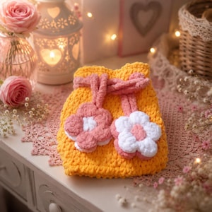 Crocheted cuddly bag with drawstring and flower decoration