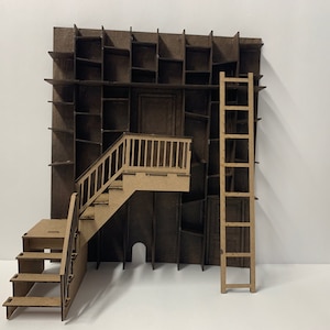 May include: A miniature model of a building with a brown facade, a wooden ladder, and a staircase leading to a small balcony. The facade is decorated with a series of rectangular cutouts, resembling shelves or windows.