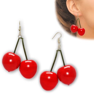 Könnte beinhalten: Ein Paar rote Kirsch-Ohrringe mit grünen Stielen und goldenen Haken. Die Kirschen sind glänzend und sehen realistisch aus.