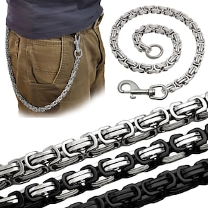 Könnte beinhalten: Eine silberfarbene Metall-Geldbörsenkette mit einem komplexen byzantinischen Gliedermuster. Die Kette verfügt über einen Karabinerverschluss an einem Ende und einen runden Ring am anderen. Eine zweite Version ist in schwarzer Ausführung.