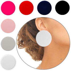 Könnte beinhalten: Ein Set großer, runder Statement-Ohrringe in verschiedenen Farben, darunter Pink, Rot, Dunkelblau, Schwarz, Hellrosa, Grau und Weiß. Die Ohrringe werden am Ohr eines Models gezeigt.