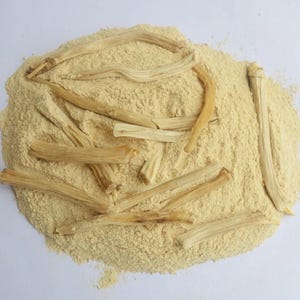 以下が含まれることがあります： 薄い茶色の粉の山の上に、細長く薄い茶色の棒がいくつか置かれている