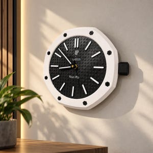 Puede incluir: Un reloj de pared octogonal con un bisel blanco que presenta ocho pernos hexagonales negros. La esfera negra tiene un patrón de cuadrícula texturizado, marcadores de hora blancos y manecillas blancas. El texto dice AP x Swatch y Roya Pop.