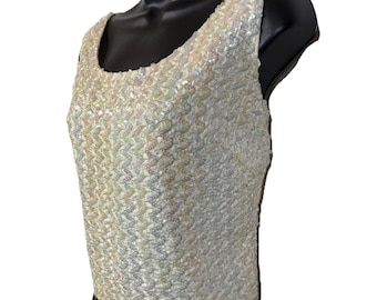 Top de lentejuelas blancas iridiscentes estilo vintage años 50 y 60, con cremallera en la espalda y escote redondo, ideal para fiestas glamurosas.