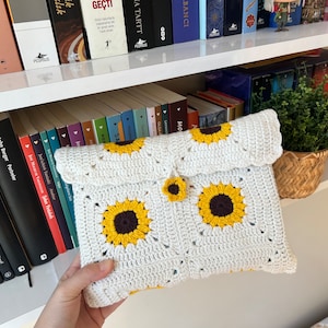 Puede incluir: Clutch blanca de crochet con dise&ntilde;o de girasol. La bolsa tiene cierre de solapa y un peque&ntilde;o bot&oacute;n de girasol.
